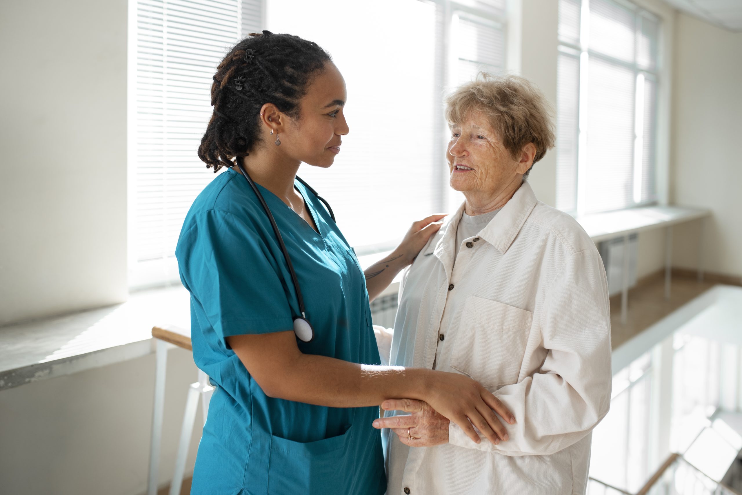 Enfermeira conversa com paciente idosa