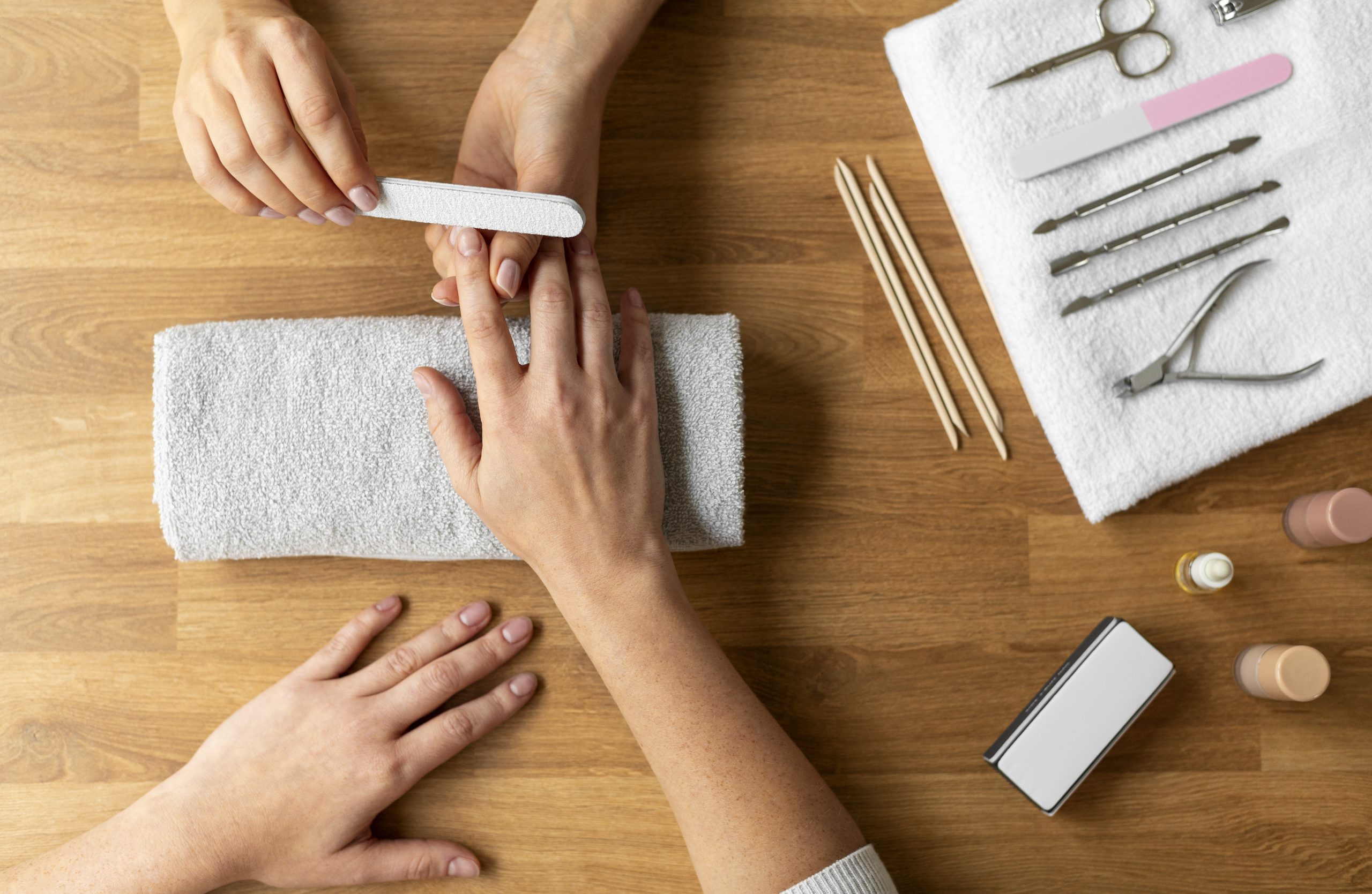 Manicure lixa unhas das mãos de uma cliente