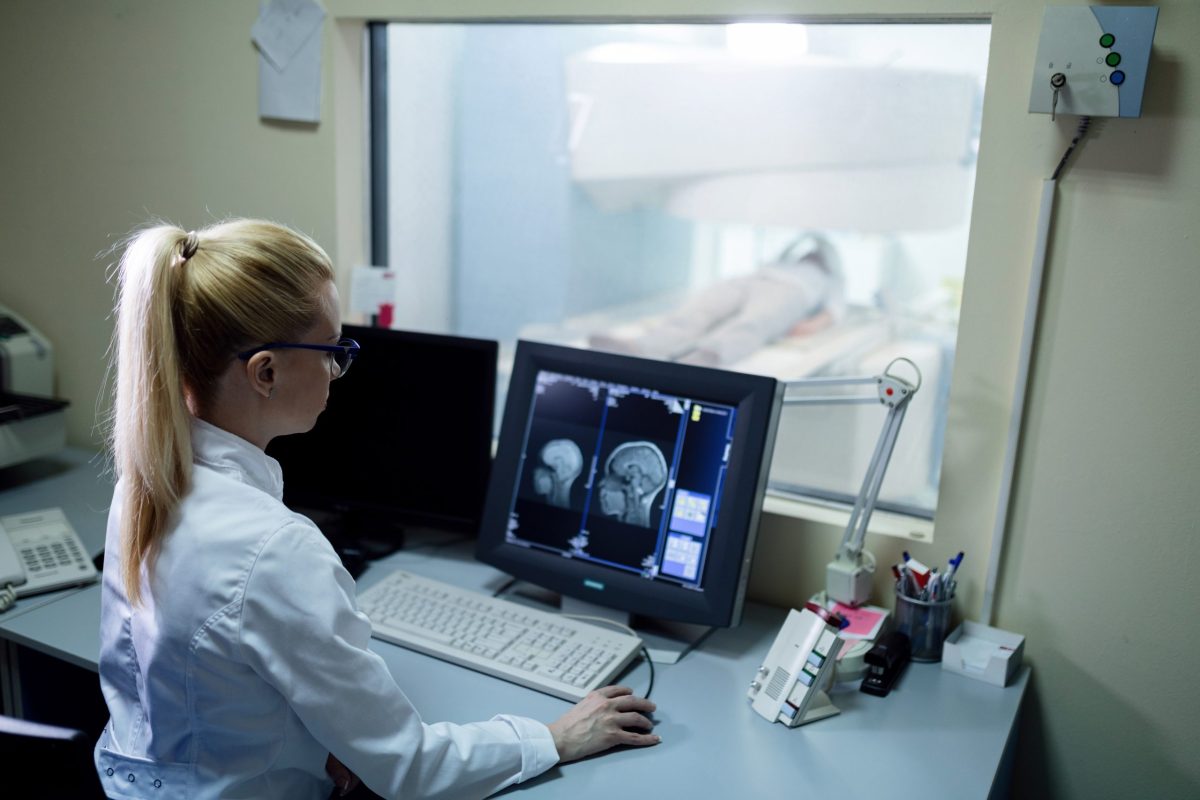 Técnica em Radiologia supervisiona exame de ressonância magnética de paciente