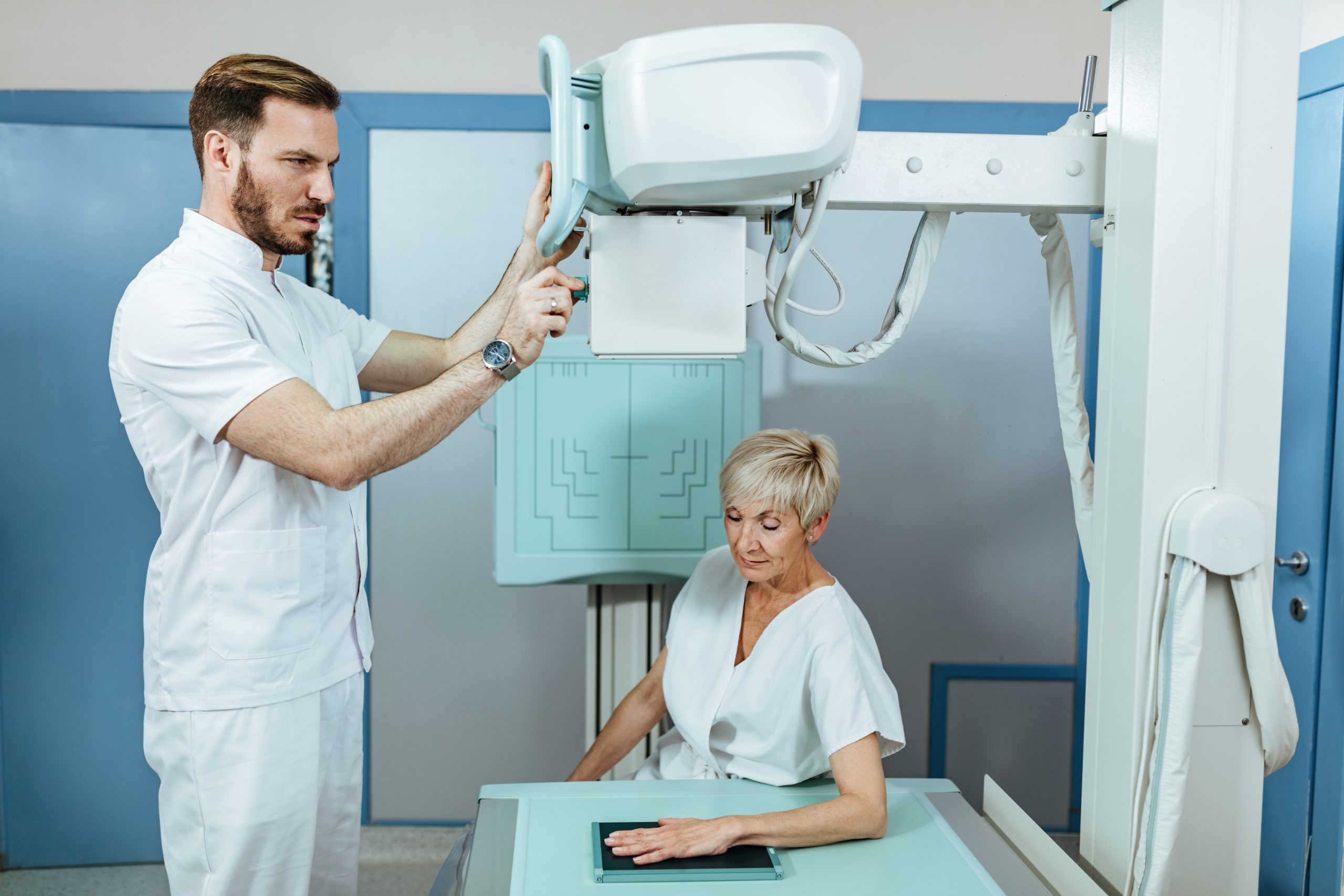 Técnico em Radiologia tira Raio X de mão de paciente